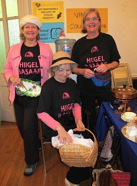 Esto Boutique head honcho Rutt Veskimets serving a very exited customer who did her part to help raise the AKEN Basaar’s earning past the $13,000 mark.  Photo: Hille Viires, Montreal.