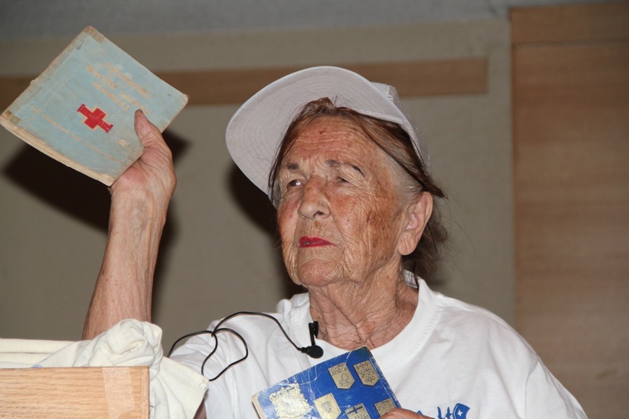 Legendary long-time Swimming instructor Mai Kreem holds up her Red Gross book while recalling times gone by. She took advantage of the need to get people's attention by using her whistle. Photo by Tauno Mölder