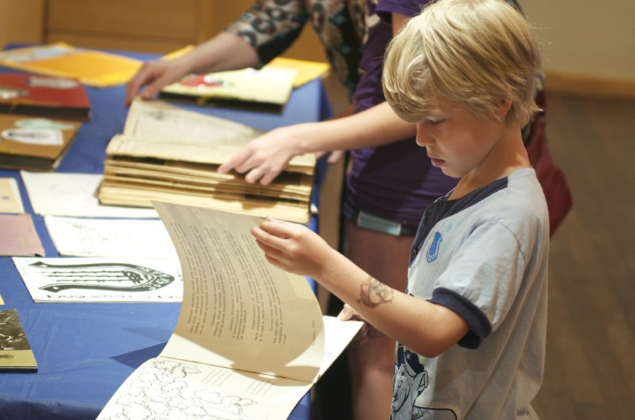 Camper Stephen Jenkins, whose ema is Tiina Haamer Jenkins, looks through the history- and scrapbooks on display at Jõekääru film night. Photo by Peeter Põldre