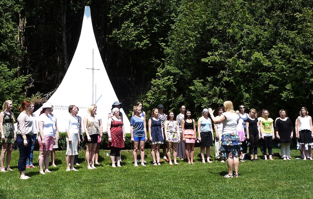 The inspiring memorial monument provides the background and reason for the ceremony enacted by the Tartu Ülikooli Akadeemiline Naiskoor (University of Tartu Academic Female Choir) at Seedrioru on May 20. It marked the end of a historic concert-tour. In the photo the choir, conducted by Triin Koch, is performing one of the patriotic songs that is part of their ever-present repertoire. Photo: Andres Raudsepp.