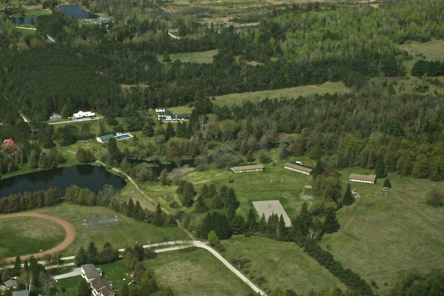 Vaade Jôekääru maa-alale 2012. a kevadel. Keskel: endine talumaja, millele on söögisaal ja tantsusaal juurde ehitatud. All paremal: kolm suvekodu tare ning hiljuti rajatud rannavõrkpalliväljakud. All vasakul: Jõekääru staadion, kus asub Kanada riigi esimene meetermõõdustikuga jooksurada. Keskel: uus saunamaja koos supelbasseiniga. Vasakul, üleval (valge katusega): Timmase nimeline kunstitare, mille annetas Jõekääru suvekodule Erika ja Osvald Timmase mälestusfond. Kunstitarest vasakul: traktori- ja tööriistakuur. Suvekodu hooneid ja tegevusala ümbritseb haljasala, mis on suvekodu ajal laagri kasutuses ning muudel aegadel, aasta jooksul Jõekääru krundiomanikele kasutatav - Foto: Toomas Kütti