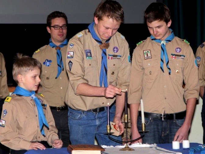 Lighting ceremonial candles at the recent celebrations of Scout Troop Kalev’s 60th anniversary are Thomas Osso, Taavo Tralla and Markus Tralla. Photo: Maimu Mölder.