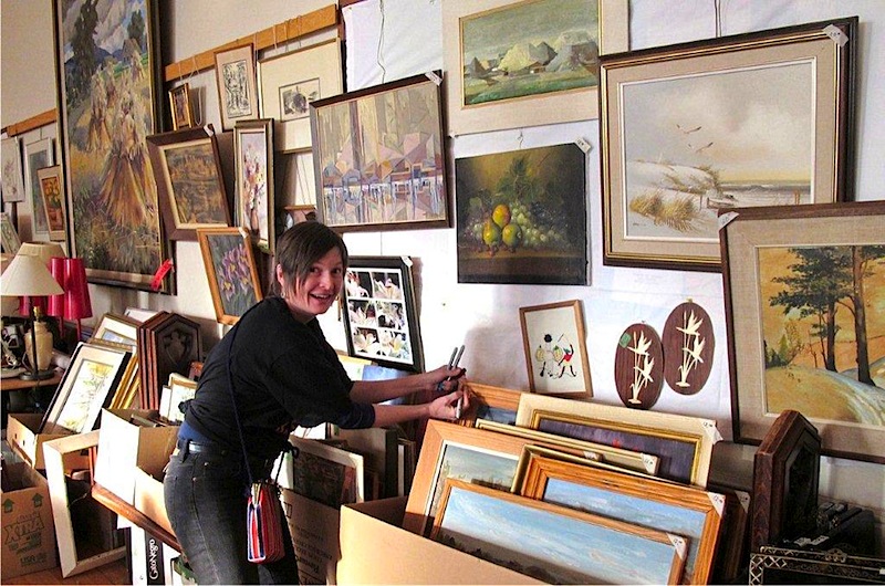 Pictured is the art and frame department at AKEN Basaar #23 before "golden-tongued" saleswhiz Ellen Valter sold the walls bare...