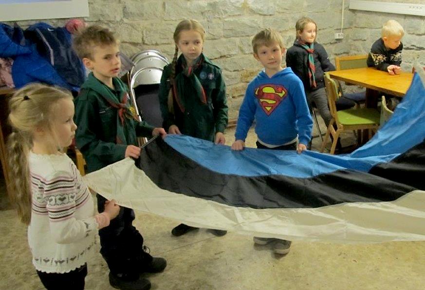 Merili, Karl August (Kusti), Ketlin ja Oliver on kogunenud ümber Eesti trikoloori, harjutamaks selle kokkupanemist nii, nagu see toimuks pärast lipulangetamist laagris. (Alati mõjub julgustavalt, kui Superman valvab lippu – aitäh, Oliver!) Tänavu 24. veebruari päikesetõusul toimus kaks suuremat riigilipu heiskamise tseremooniat: Toompeal Pika Hermanni torni ja Pärnus Rüütli platsil. Soovitatav oli seal ja ka Kaitseväe paraadil Pärnu Keskväljakul kanda võimaluse korral kaelarätti, koolimütsi, teklit või sõjakübarat. Foto: Riina Kindlam