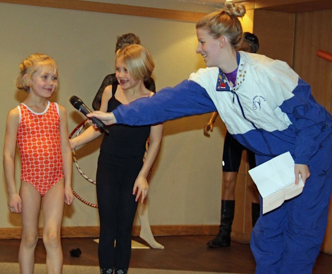 Amicitia's "esinaine" and former gymnast Kristina Põldre pursuading mini-gymnasts Imbi and Eila Uukkivi to demonstrate a few of their favourite gymnastics moves at Küünlapäev - photo by Lillian Lennox of korp! Amicitia