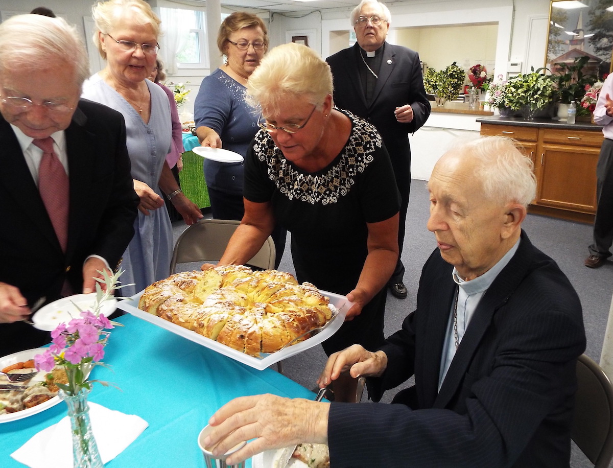 Juubelikringel juubilarile. Paremalt juubilar 100-ndat sünnipäeva tähistav õpetaja Valdeko Kangro, koguduse õpetaja Uudo Tari, kringli tooja Karin Maandi, kringli küpsetaja Tiiu Anson, koguduse esimees Avo Ora abikaasa Tiiuga - foto: Airi Vaga (2016)