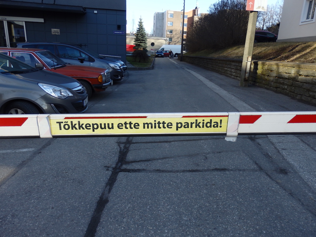 "Do not park in front of the <tõkke/puu>." The bar (<puu>) is a barrier which stops you (<tõkestab sind>) from passing through. In this case, it controls entry into the <parkla> or <parkimis/plats> of the Vanemuise teater in Tartu.