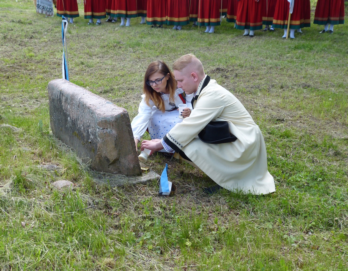 Juhtivad TÜ kammerkoori noored, Nele Dresen ja Robert Pirk, süütavad küünlad mälestuskivi ees - foto: Andres Raudsepp (2017)