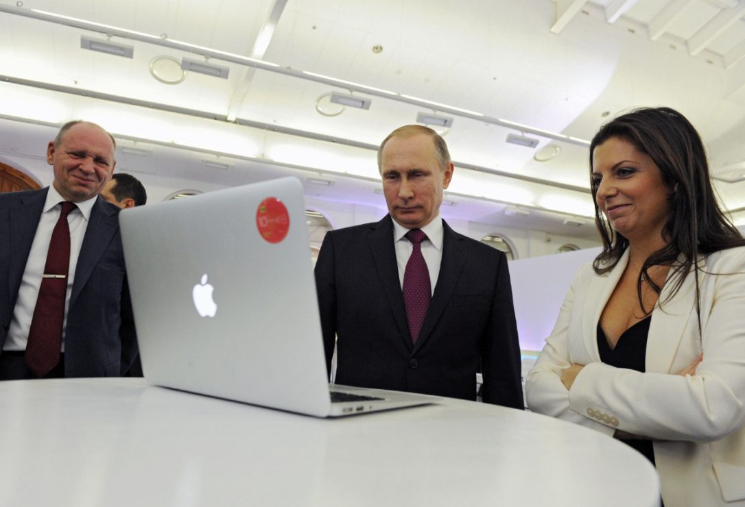 In this December, 2015 file photo, Margarita Simonyan, the editor-in-chief of state-funded RT television network, right, Russian President Vladimir Putin, centre, and Kremlin's first deputy chief of staff, Alexei Gromov, left, attend an exhibition marking RT's 10th anniversary in Moscow. The Kremlin voiced dismay Thursday Nov. 30, 2017 over the withdrawal of a Russian state-funded TV station's credentials in the U.S. and warned of a quick retaliation. (MIKHAIL KLIMENTYEV / AP)