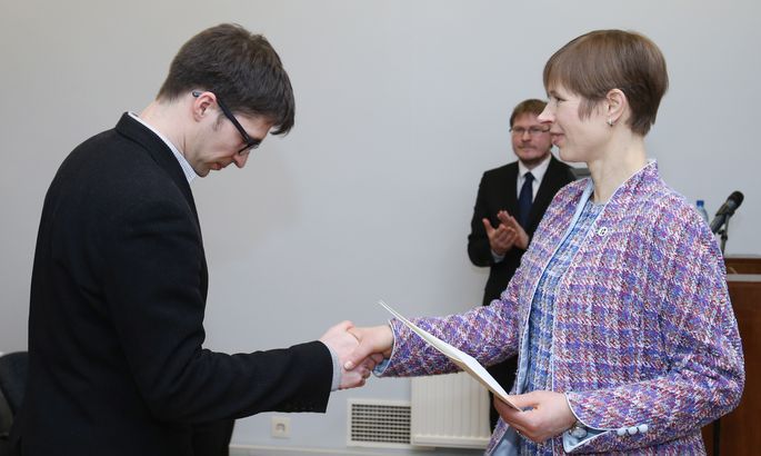 President Kersti Kaljulaid õnnitlemas noort teadlast Rasmus Kaske rahvapärimuse kogumise eest 26. veebruaril Eesti Kirjandusmuuseumis toimunud mitmiküritusel. Selle päeva raames esitleti ka uut, kaheköitelist eesti rahva elulugude kogumikku, kus ka põgenenud ning kaugele rännanud eestlaste lugusid. Taustal on Eesti Rahvaluule Arhiivi juhataja Risto Järv. Foto: Sille Annuk, Tartu Postimees