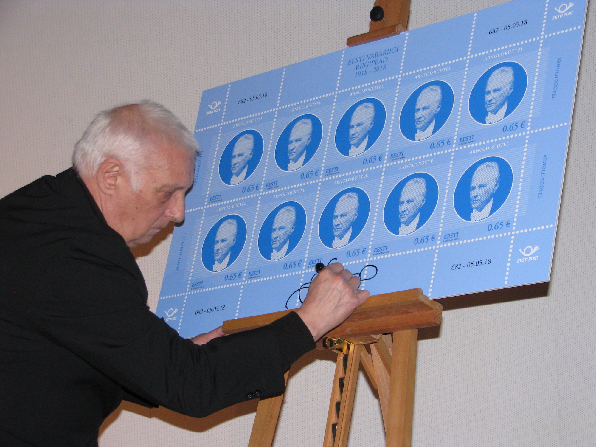 Lembit Lõhmus signeerimas enda kujundatud postmargi plakatit.