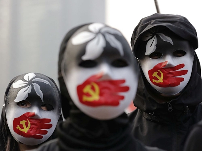 People wearing masks stand during a rally to show support for Uighurs and their fight for human rights in Hong Kong, Sunday, Dec. 22, 2019. LEE JIN-MAN / The Associated Press