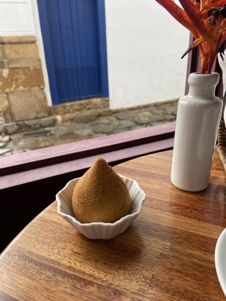 Noshing on coxinhas (chicken croquettes) in the town of Paraty