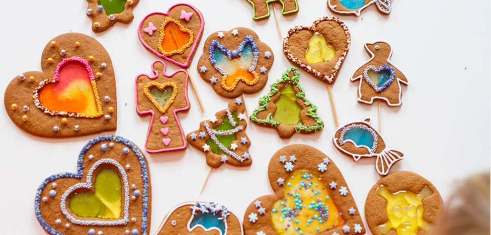 Colourful gingerbread cookies with stained-glass candy centres, decorated in festive shapes like hearts, angels, and trees (source: PiparkoogiMaania)