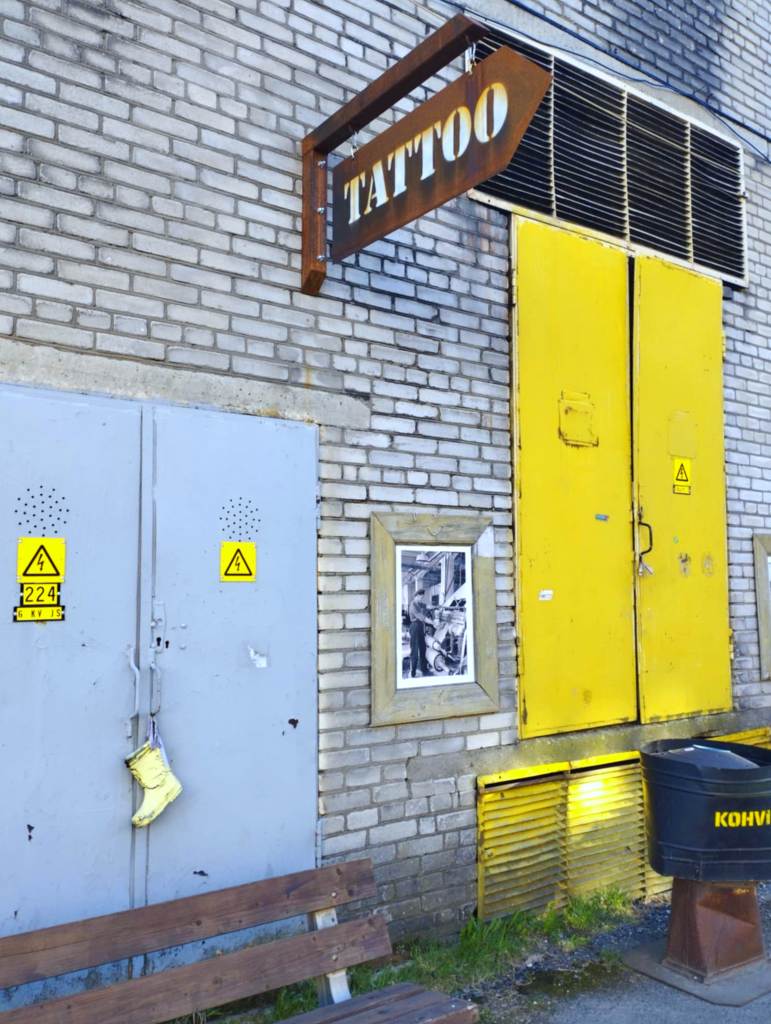A rusty sign pointing to a tattoo studio on the main street of Põhjala Tehas (photo: Jerry Mercury)