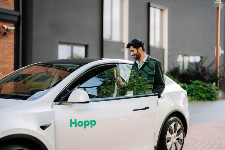 Hopp ridesharing app vehicle with a driver getting inside the car