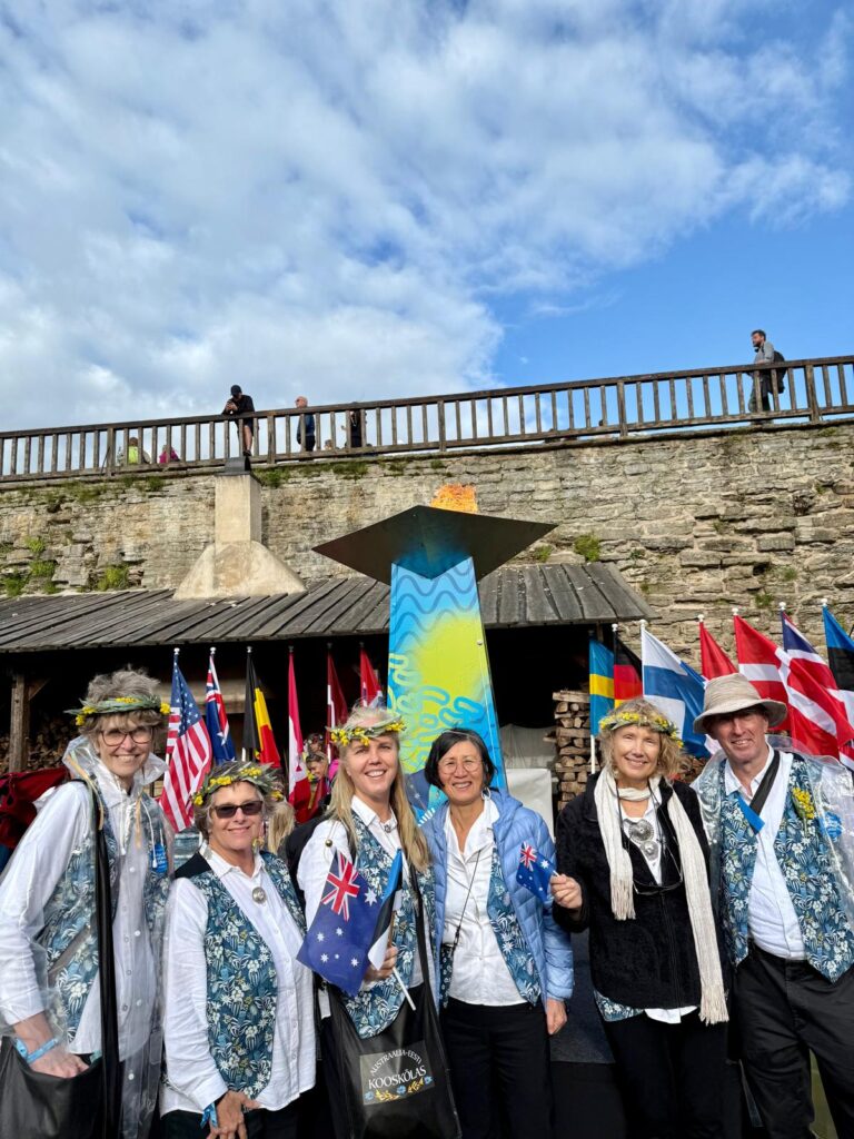 Six members of Kooskõlas proudly pose with the Laulu- ja Tantsupidu “Iseoma” flame in Narva. From left: Siiri Iismaa, Karel Baum, Esmée Okamoto, Donna Mak, Pia Raynard, and Choir Director Kieran Scott. Each member had the honour of holding the flame as it was passed along the line of singers on the street. Photo from the private collection of Esmée Okamoto.