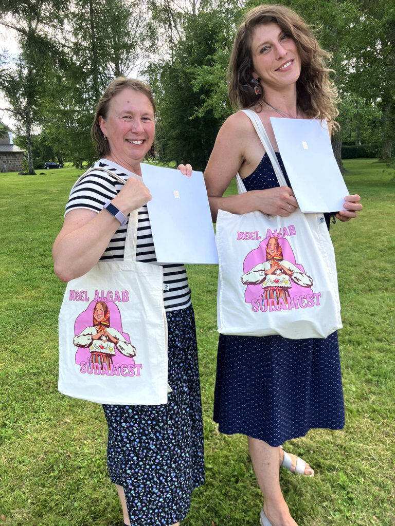 Tänavu said kaks Annaliisat ,,noore sädeõpetaja“ tunnustused. Tegelikult on vasakul Janne Sepp, Portlandi Eesti Kooli juhataja ja õpetaja. Ta esindab oma tütart Anna-Liisa Seppa, kes pälvis tunnustuse USA teisel kaldal, New Yorgi Eesti Koolis pühendunud tegutsemise eest. Paremal on Annaliisa Asveit, kes õpetab Londoni Eesti Koolis. Õlakottide, millel tekst ,,KEEL ALGAB SÜDAMEST“ autor on USAs tegutsev noor eesti kunstnik Riivo Kruuk, kes on ka varem noore sädeõpetaja tunnustuse pälvinud. Foto: Riina Kindlam