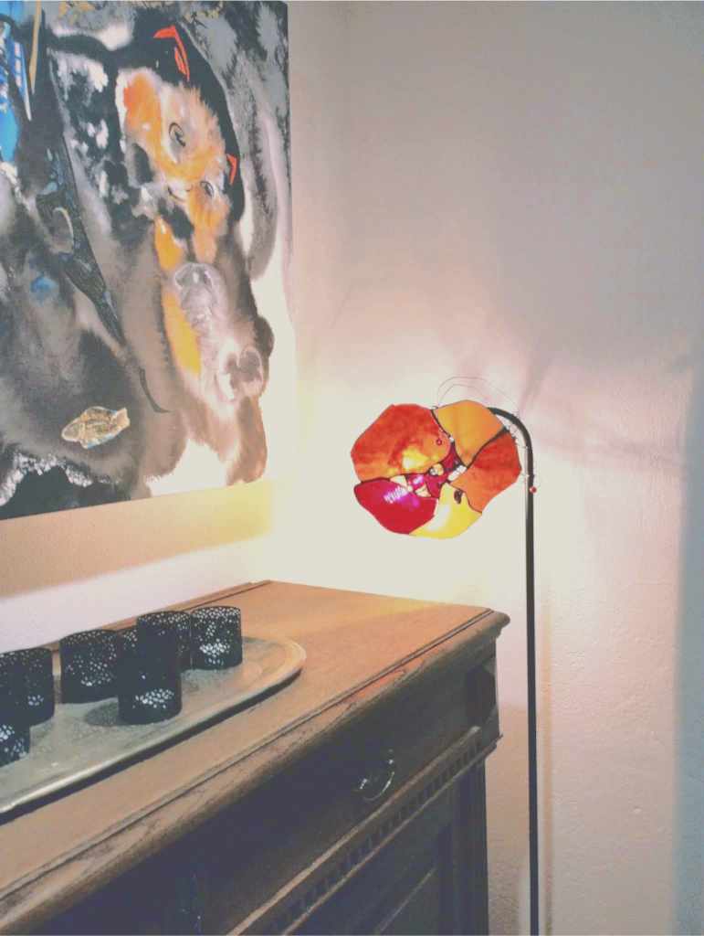 The second hall of Lummus, with Maire Valdma’s abstract painting of a pointy-eared feline figure illuminated by a poppy shaped stained-glass lamp (photo: Jerry Mercury)