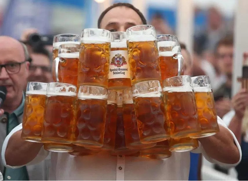 Oliver Strümpfel carrying the world record breaking 29 steins of beer (source: beerinfo.com)