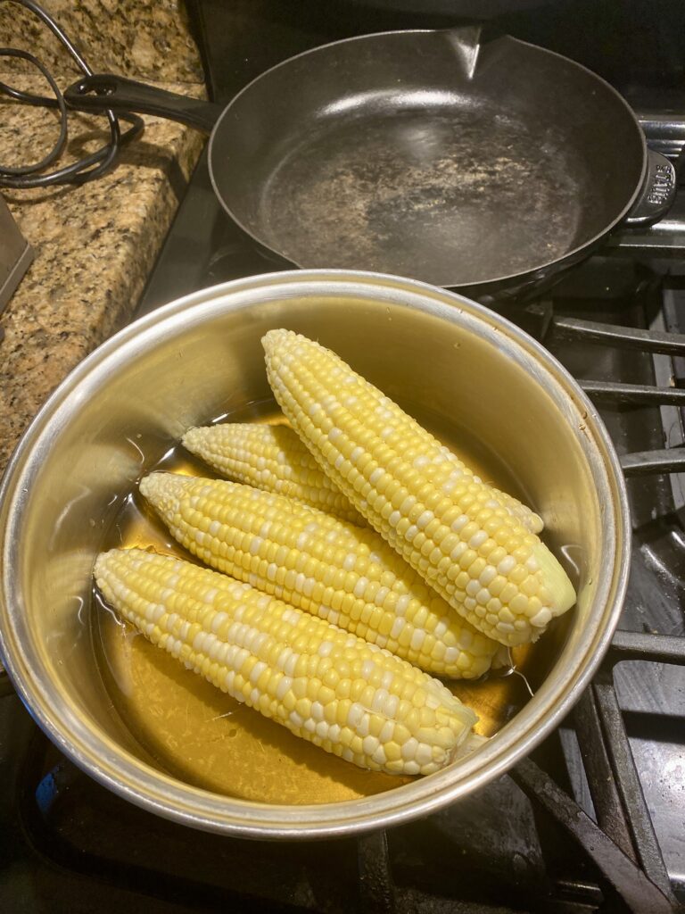 Cooking the ears of corn in the thyme water