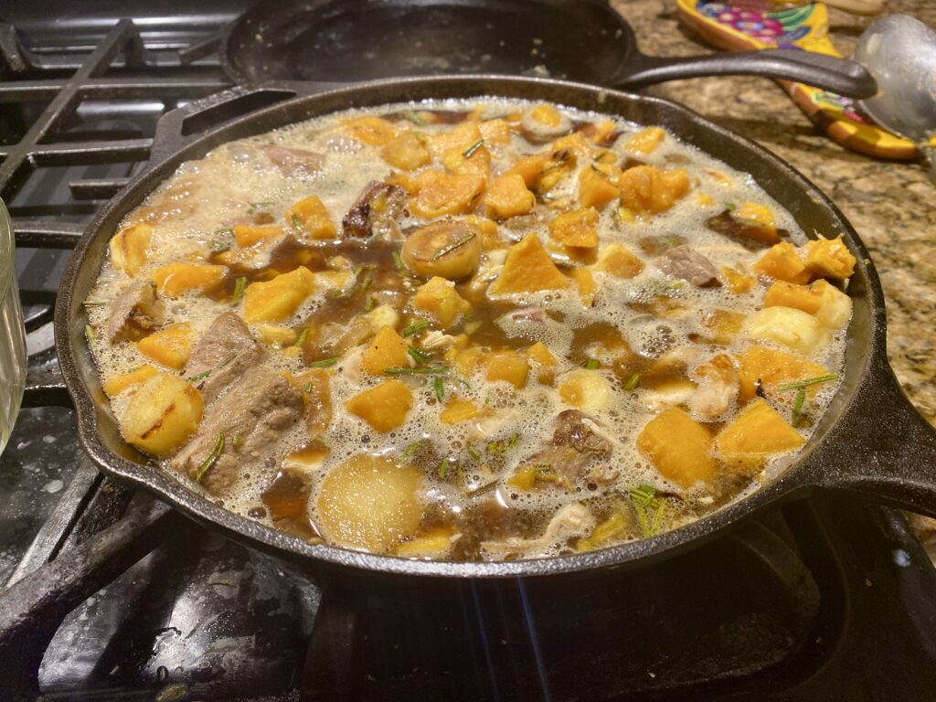 When the beef and vegetables have cooked thoroughly and things are a little bit stuck onto the sides of the pan, pour in the ale.