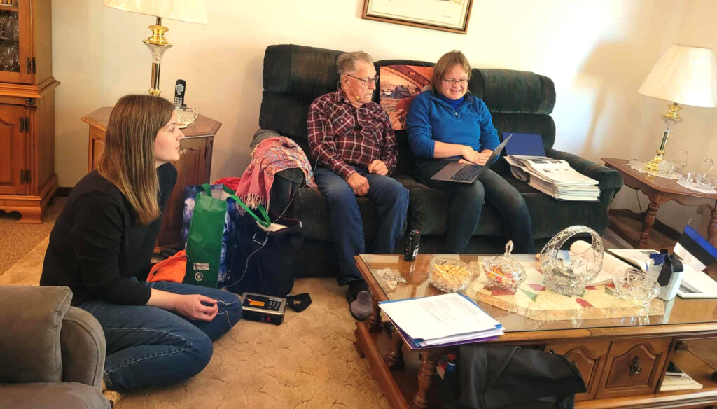 Stettler, Alberta. Keeleteadlane Kaidi Lõo näitab Deane Kerbesile pilte, mida eesti keeles kirjeldada, salvestamas on Maarja-Liisa Pilvik. Jäädvustatakse enne 1955. aastat Albertasse saabunud eestlaste kõnet. Foto: Liina Lindström