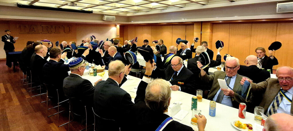 Kommersist osavõtvad korporandid lauldes Gaudeamus igitur tervitavad akadeemiat oma korporatsiooni tekli tõstmisega.