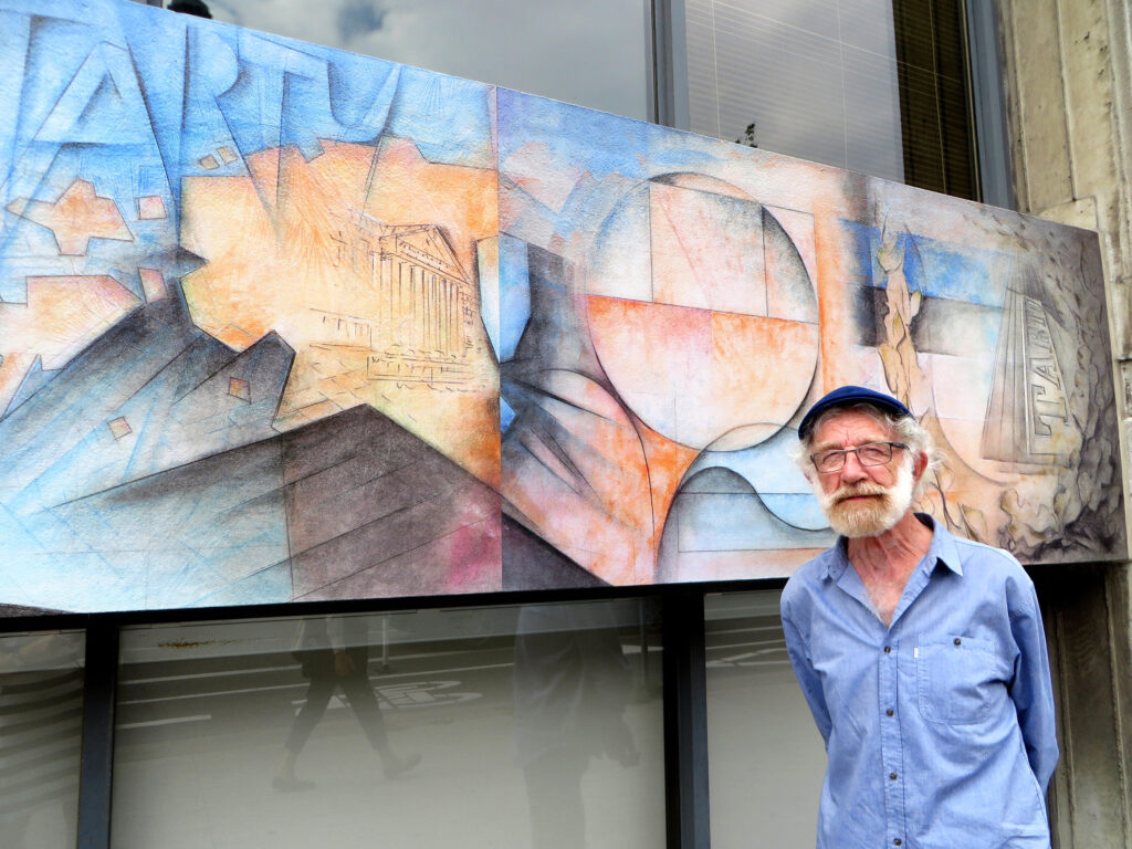 Arne Roosman oma valmistatud seinapannoo ees Tartu College’i fassaadil. Foto: EE arhiiv 