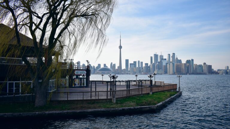 View of Toronto's iconic skyline from a serene lakefront perspective by Cirilo Valentin